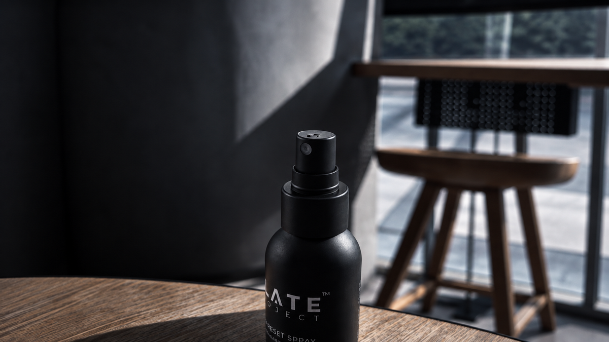 SLATE Hair Reset Spray standing on a wooden desk in a dark modern interior.