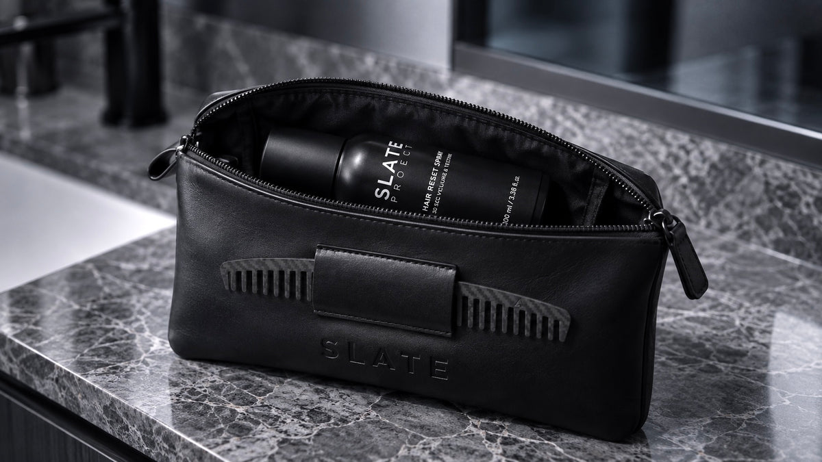 An open black SLATE tactical sleeve on a gray marble counter with Hair Reset Spray inside.
